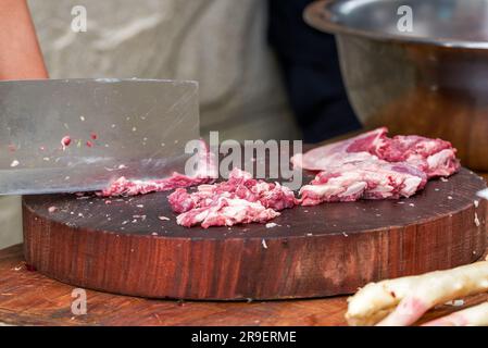 Un chef découpe le porc et prépare les ingrédients Banque D'Images