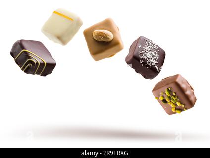 Assortiment de pralines au chocolat flottant sur fond blanc Banque D'Images