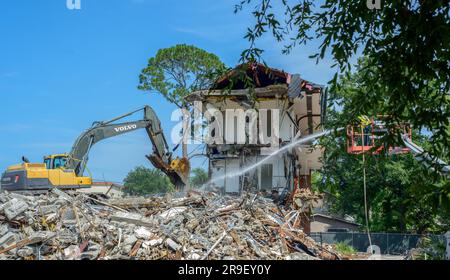 NEW ORLEANS, LA, États-Unis - 23 JUIN 2023 : projet de démolition de bâtiments actifs avec une pelle hydraulique et un travailleur utilisant un tuyau d'eau Banque D'Images