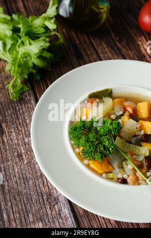 Gros plan de minestrone végétalien sain avec des patates douces, du céleri, des tomates et des haricots. Une alimentation saine. Concept de régime végétalien. Banque D'Images