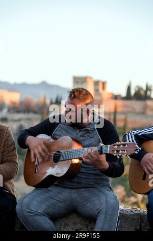 Grenade, Espagne - 22 février 2022 : groupe de musiciens tziganes qui exécutent des arts du flamenco au célèbre Mirador de San Nicolas en regardant vers le palais de l'Alhambra Banque D'Images