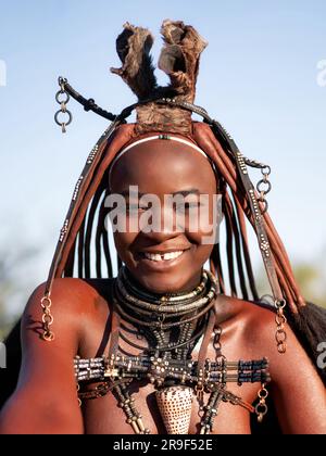 Joyeuse femme Himba souriante, habillée dans le style traditionnel en Namibie, Afrique. Banque D'Images