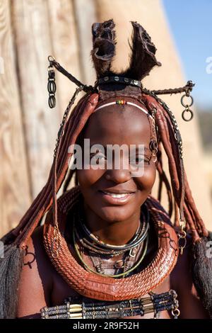 Joyeuse femme Himba souriante, habillée dans le style traditionnel en Namibie, Afrique. Banque D'Images