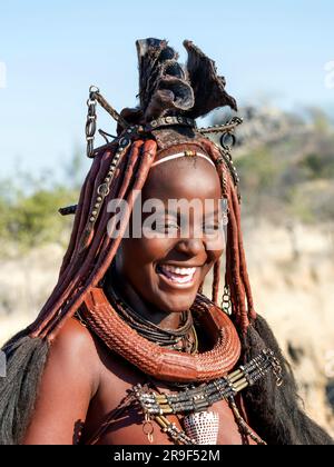 Bonne femme Himba souriante, habillée dans le style traditionnel en Namibie, Afrique. Banque D'Images