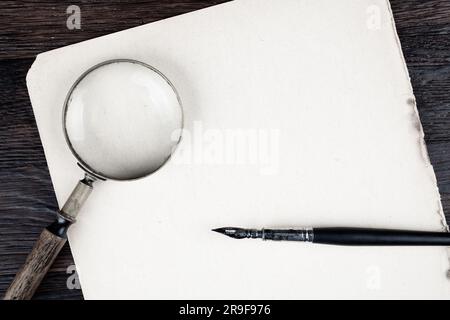Loupe antique vintage avec stylo plume d'encre ancienne sur fond de papier Banque D'Images