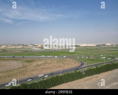 Une vue aérienne d'une autoroute entourée d'un luxuriant champ vert situé à proximité d'un grand complexe industriel Banque D'Images