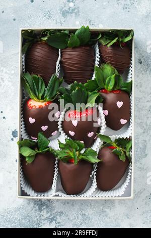 Fraises gourmandes enrobées de chocolat sur fond clair. De délicieuses fraises dans une boîte pour la Saint-Valentin. Banque D'Images