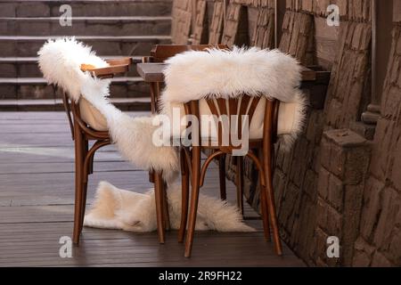 chaises en bois avec couvertures en fourrure blanche dans une chambre vide, mobilier en bois, décoration de dortoir Banque D'Images