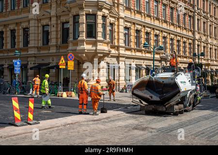 Ouvriers et machines à asphalter à l'angle de Pohjoisesplanadi et Kluuvinkatu dans le district de Kluuvi à Helsinki, en Finlande Banque D'Images