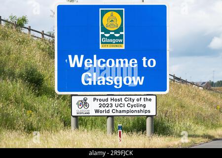 Fier ville hôte des Championnats du monde de cyclisme UCI 2023 panneau attaché au panneau Bienvenue à Glasgow sur l'autoroute M8, Glasgow, Écosse, Royaume-Uni Banque D'Images