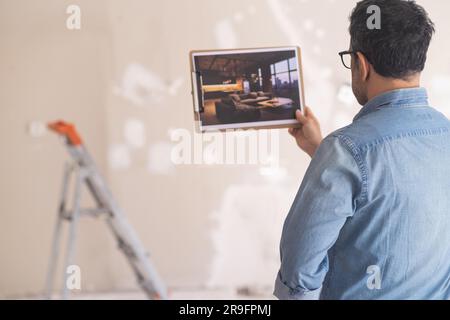 Homme en verre regardant la photo avec style loft intérieur design debout dans la chambre Banque D'Images