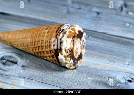 Biscuit caramélisé crème glacée au chocolat au cacao et au cône de vanille avec garniture de biscuits et de noix dans des cônes de cachets croustillants, fusion de la glace froide crea Banque D'Images