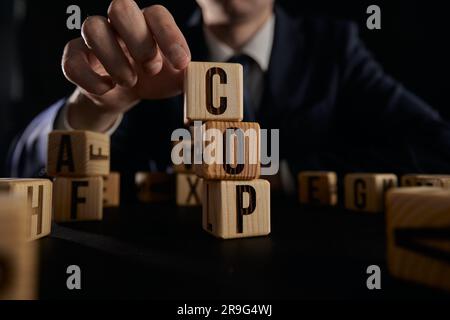 Homme d'affaires a recueilli le mot COP de cubes en bois Banque D'Images