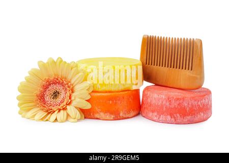 Barres de shampooing unies colorées avec fleur et peigne sur fond blanc Banque D'Images