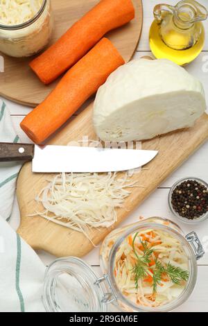 Cuisson d'une délicieuse soupe de choucroute. Chou frais haché et ingrédients sur table en bois blanc, plat Banque D'Images