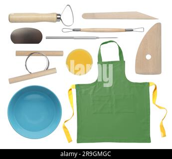 Ensemble d'outils de poterie, tablier et bol en céramique sur fond blanc Banque D'Images