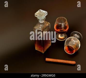 Cigare cubain, carafe en cristal et deux verres de whisky sur fond noir. Gros plan. Banque D'Images