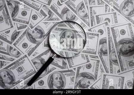 Loupe sur une pile de cent dollars US d'argent Banque D'Images