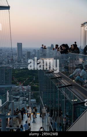 Tokyo, Japon - 04 mai 2023 : les gens apprécient le coucher de soleil sur le paysage urbain de Tokyo depuis le bureau d'observation du ciel de Shibuya dans la capitale japonaise. Banque D'Images