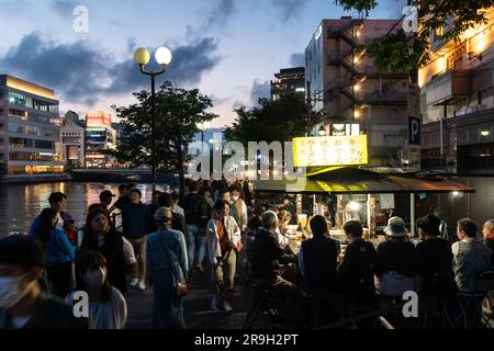 Fukuoka, Japon - 20 mai 2023: Les gens apprécient la cuisine traditionnelle de rue dans le marché nocturne de Fukuoka le long de la rivière Naka à Kyushu au Japon Banque D'Images