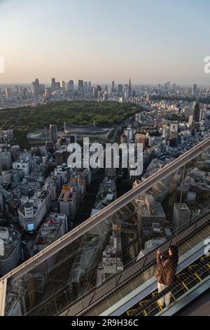 Tokyo, Japon - 04 mai 2023 : les gens prennent des photos tout en montant l'escalier mécanique au coucher du soleil sur le bureau d'observation du ciel de Shibuya dans la capitale japonaise Banque D'Images