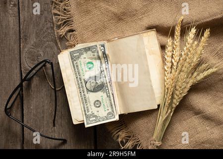 les dollars américains se trouvent sur un vieux livre sur une table en bois sur le virement de bord, de l'argent pour l'éducation Banque D'Images
