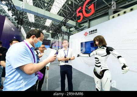 SUZHOU, CHINE - 27 JUIN 2023 - les visiteurs interagissent avec un robot fortement simulé devant le stand d'un exposant à l'exposition internationale Meta Universe Banque D'Images