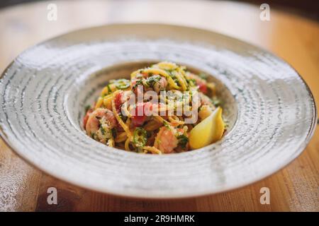 Assiette de fruits de mer, pâtes épicées aux crevettes servies sur une assiette, dans un restaurant. Banque D'Images