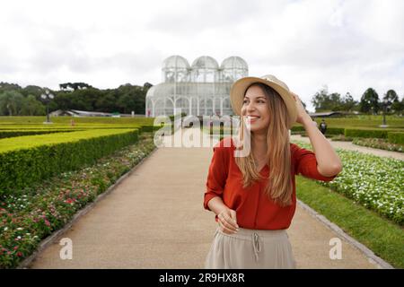 Fille avec chapeau marchant à la recherche du côté dans le jardin botanique de Curitiba, Parana, Brésil Banque D'Images