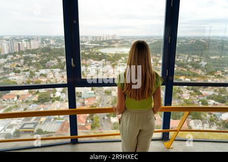 Vue arrière de la jeune femme regardant Curitiba paysage urbain de Torre Panoramica la tour panoramique de Curitiba, Parana, Brésil Banque D'Images