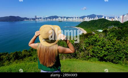 Vacances au Brésil. Vue panoramique de la jeune fille voyageur sur le point de vue appréciant Balneario Camboriu Skyline, Brésil. Banque D'Images