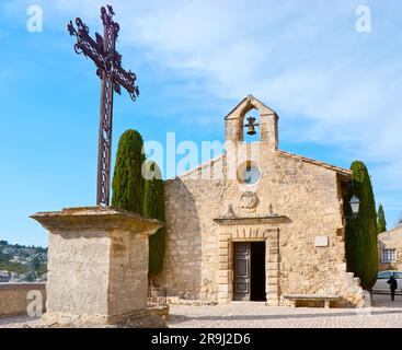 La façade de la Chapelle des Pénitents blancs (Chapelle des Pénitents blancs) avec une croix en face de celle-ci, la place de l'église Saint-Vincent, les Baux-de-Prove Banque D'Images