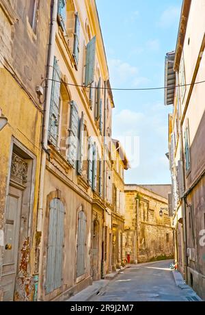 L'étroite rue sinueuse de la vieille ville avec des bâtiments historiques, des portes et des volets en bois de merde, Arles, France Banque D'Images