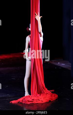 Danseuse acrobatique de danse aérienne sur tissus rouges Banque D'Images