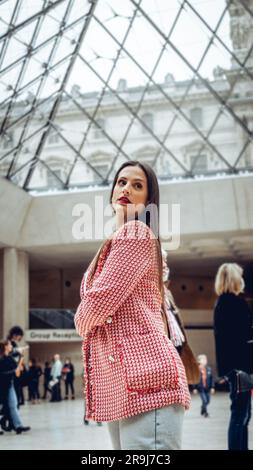 Une jeune femme debout devant un mur Uni portant un ensemble élégant Banque D'Images