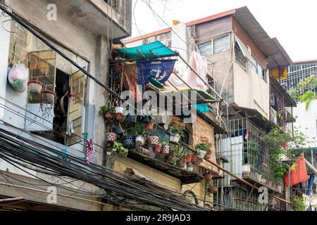 Hanoï, Vietnam-avril 2023; vue à angle bas de la façade de maisons typiques avec balcons avec câbles électriques, lignes téléphoniques accrochées dans le désordre Banque D'Images