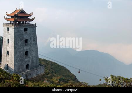 Sa Pa, Vietnam-avril 2023 ; vue panoramique de Dai Hong Chung Watchtower sur le sommet de la montagne Fanxipan avec téléphérique venant en sens inverse Banque D'Images