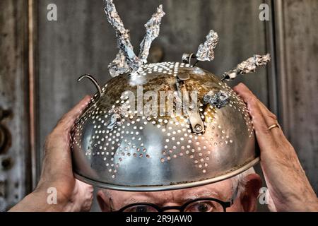 Homme portant un chapeau de Tinfoil en raison de la superstition de l'activité extraterrestre et des événements paranormaux, 2023, États-Unis Banque D'Images