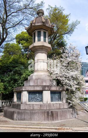 Tokyo, Japon-avril 2023 ; vue à angle bas d'une lanterne en pierre avec laquelle les reliefs de la marine des scènes de bataille du Japon impérial sont sculptés, faisant partie du style Shinto Banque D'Images