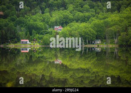 Parc national de l'Île-du-Cap-Breton, réflexions le long de Cabot Trail Ingonish, Nouvelle-Écosse, Canada. Eaux tranquilles, maisons près du paysage côtier du lac. Banque D'Images