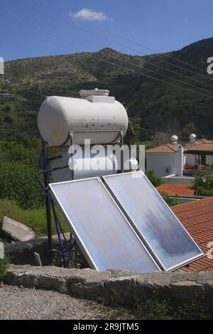 Chauffe-eau solaire avec capteurs solaires et réservoir d'eau sur le toit d'une maison, village Episkopi, République de Chypre Banque D'Images