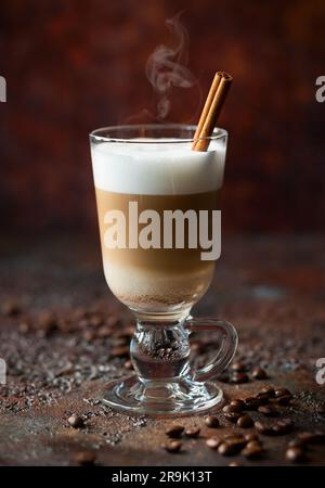 Café latte dans un grand verre avec un bâton de cannelle Banque D'Images
