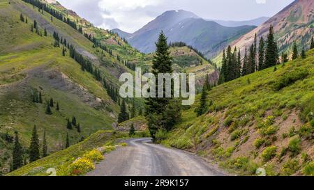 Canyon Road - Une route étroite d'arrière-pays qui s'enroule dans un canyon abrupt lors d'une journée d'été houleuse. Crested Butte, Colorado, États-Unis. Banque D'Images