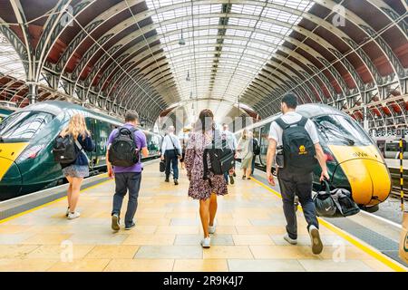 Les passagers se précipitent le long d'une plate-forme à la gare de Paddington pour monter à bord d'un train. Banque D'Images