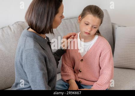 Inquiète millénaire caucasienne dame calme malheureux fille de l'adolescence, parler, aide avec des problèmes dans la salle de séjour Banque D'Images