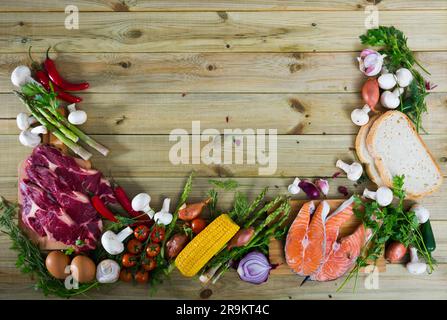 Bœuf cru, saumon et légumes sur fond de bois Banque D'Images
