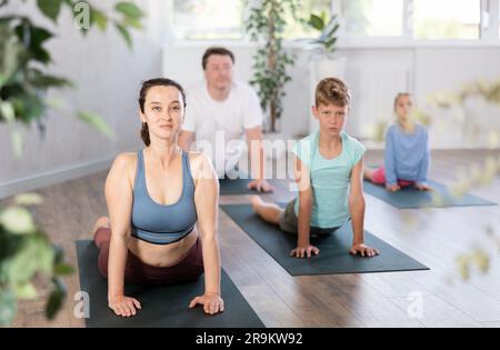 Les enfants de préadolescents pratiquent le yoga et le Pilates avec leurs parents Banque D'Images