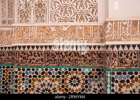 Carreaux orientaux et stuc calligraphique sur un mur d'un madrassa, au Maroc Banque D'Images