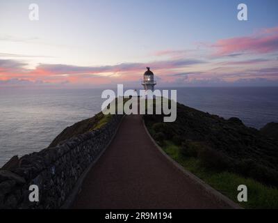 Chemin piétonnier menant à un phare blanc historique situé sur une falaise surplombant l'océan Cape Reinga Aupouri Peninsula Northland No Banque D'Images