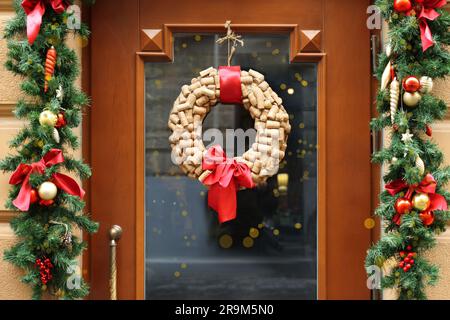 Belle couronne de Noël faite de bouchons de vin accrochés à une porte en bois Banque D'Images